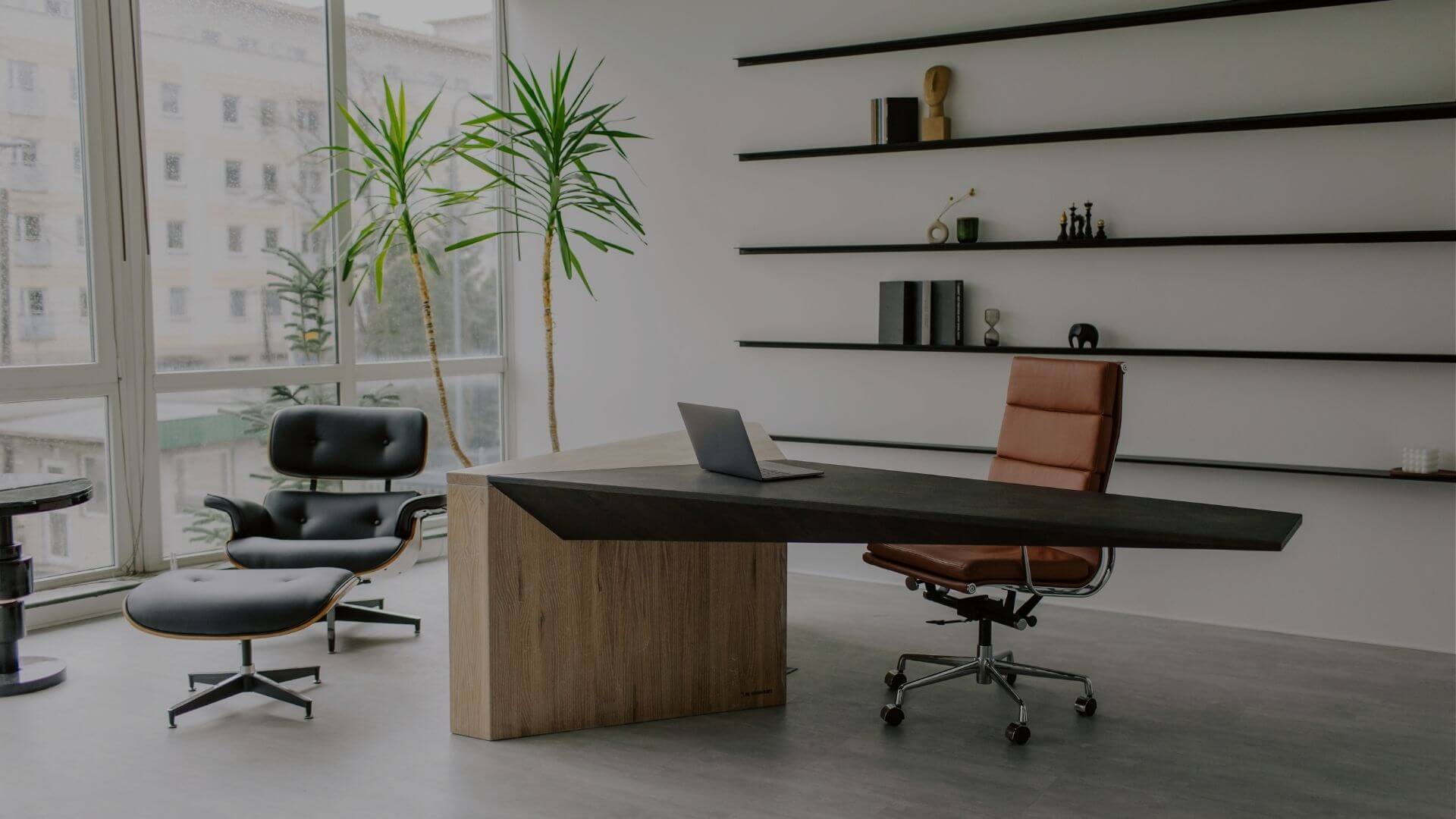 Modern commercial office workspace with executive desk, seating area, and large windows in Stockton, CA office building.